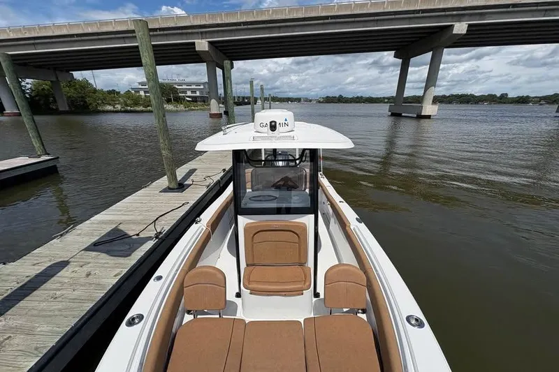 Slide: The Image of 2021 Seahunt 255 Ultra boat docked under a bridge on a sunny day. - 20