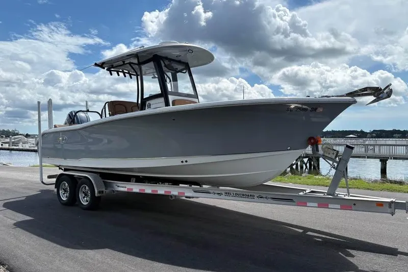 Slide: The Image of 2021 Seahunt 255 Ultra boat on trailer by waterfront under cloudy sky. - 4