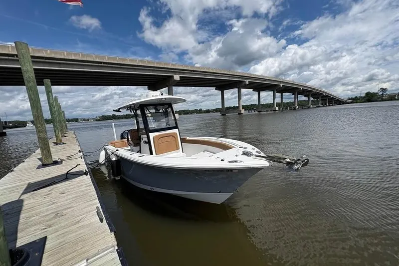Slide: The Image of 2021 Seahunt 255 Ultra boat docked by a bridge on a sunny day. - 6