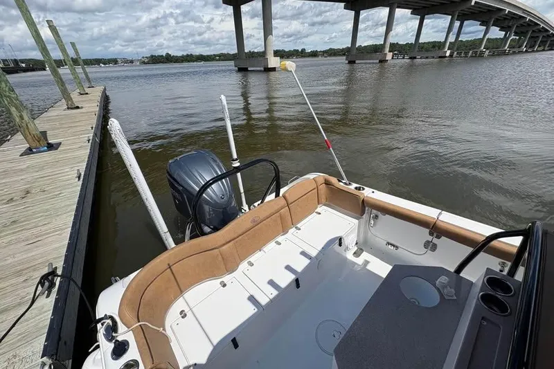 Slide: The Image of 2021 Seahunt 255 Ultra boat docked by a bridge on a calm river. - 7
