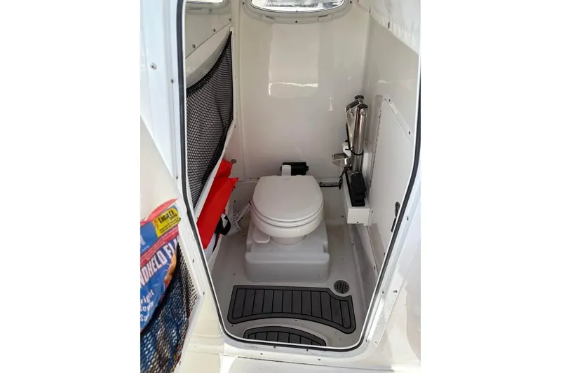 Slide: The Image of 2021 Seahunt 255 Ultra boat interior with compact marine toilet and storage. - 9