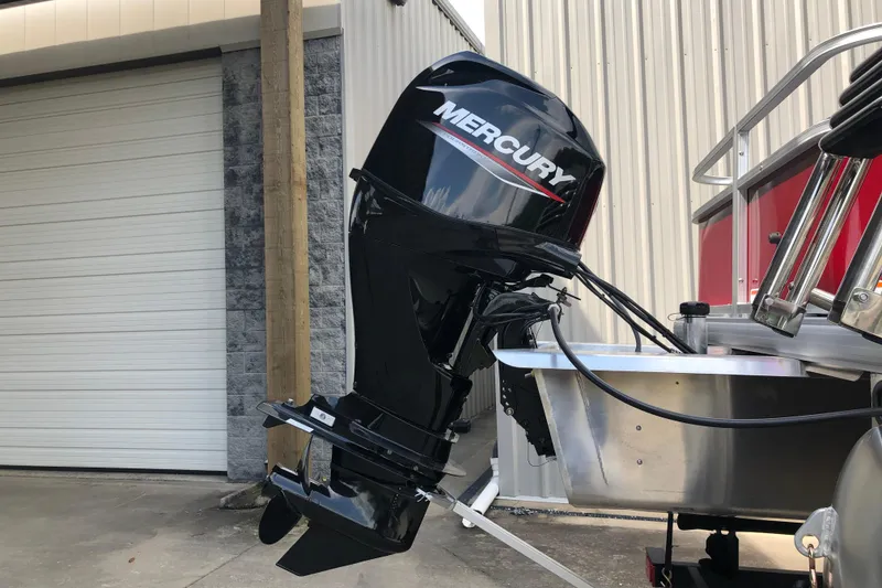 Slide: The Image of 2026 Sun Tracker Bass Buggy 18 DLX with Mercury outboard motor in a garage setting. - 15