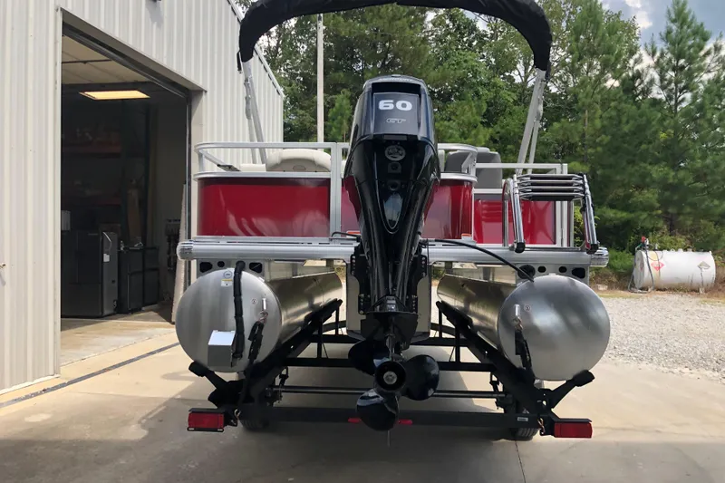 Slide: The Image of 2026 Sun Tracker Bass Buggy 18 DLX pontoon boat with 60 HP engine, parked outdoors. - 3