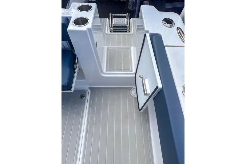 Slide: The Image of 2024 Aquasport AS DC 22 boat interior with open storage compartment and cup holders. - 9