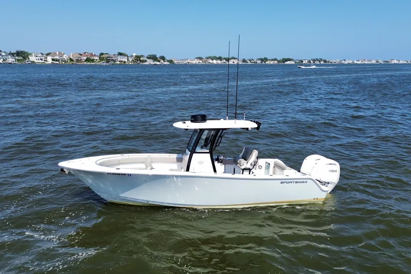 Slide: The Image of 2024 Sportsman Open 252 Center Console boat on calm water, coastal background. - 0
