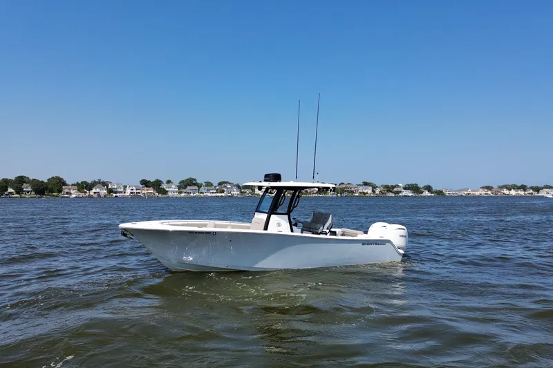 Slide: The Image of 2024 Sportsman Open 252 Center Console boat on calm water, clear sky background. - 10