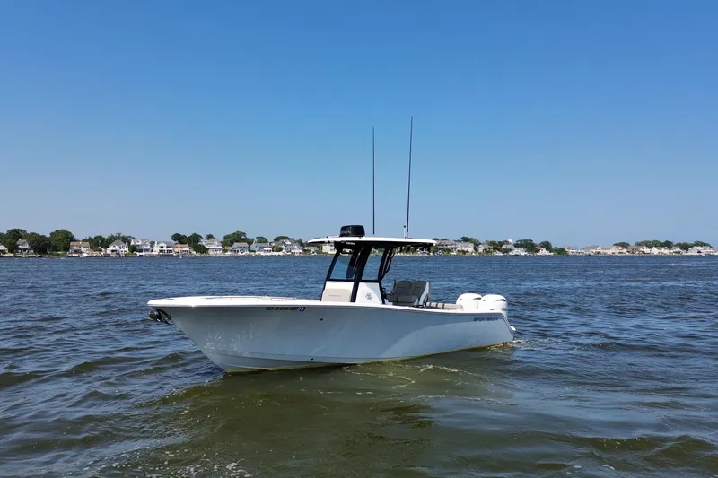 Slide: The Image of 2024 Sportsman Open 252 Center Console boat on calm water, clear sky background. - 11