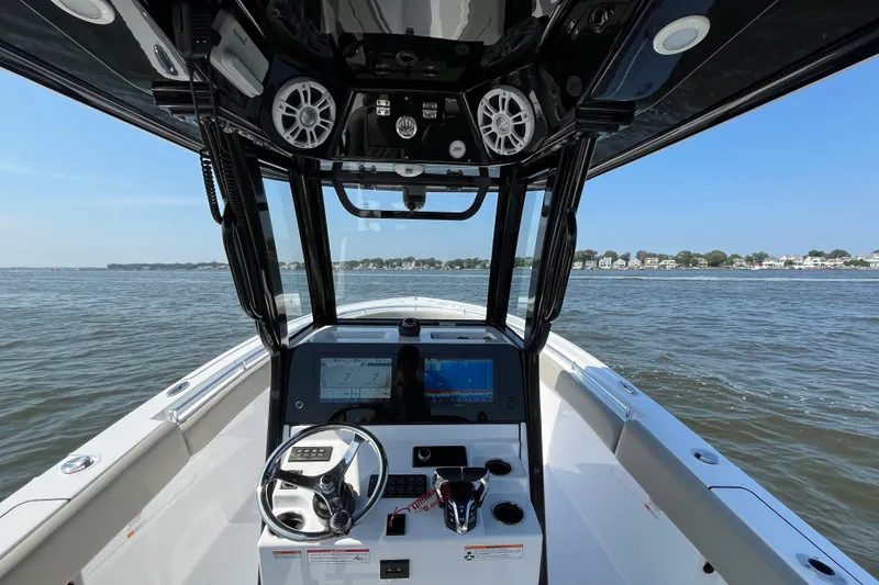 Slide: The Image of 2024 Sportsman Open 252 Center Console boat interior with steering wheel and navigation screens. - 16
