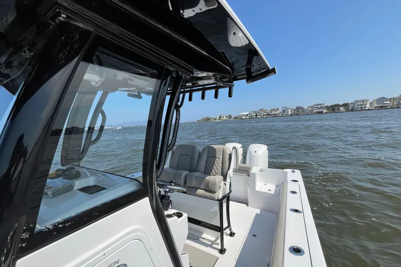 Slide: The Image of 2024 Sportsman Open 252 Center Console boat on water, coastal houses in background. - 19