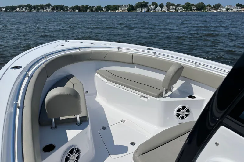 Slide: The Image of 2024 Sportsman Open 252 Center Console boat interior with cushioned seating on calm water. - 20