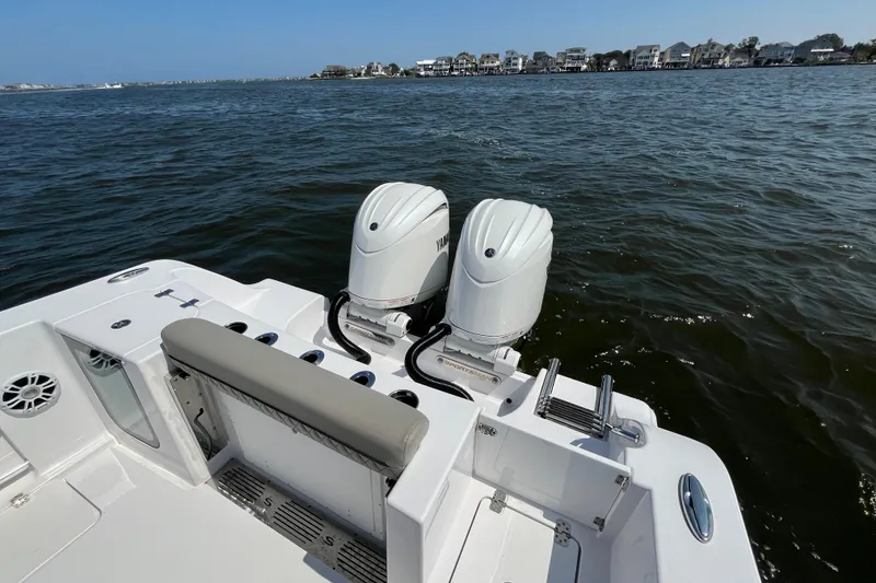 Slide: The Image of 2024 Sportsman Open 252 Center Console boat with dual engines on a calm waterway. - 22