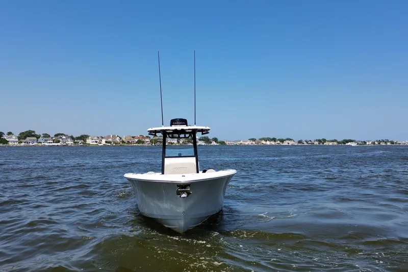 Slide: The Image of 2024 Sportsman Open 252 Center Console boat on calm water, clear blue sky. - 6