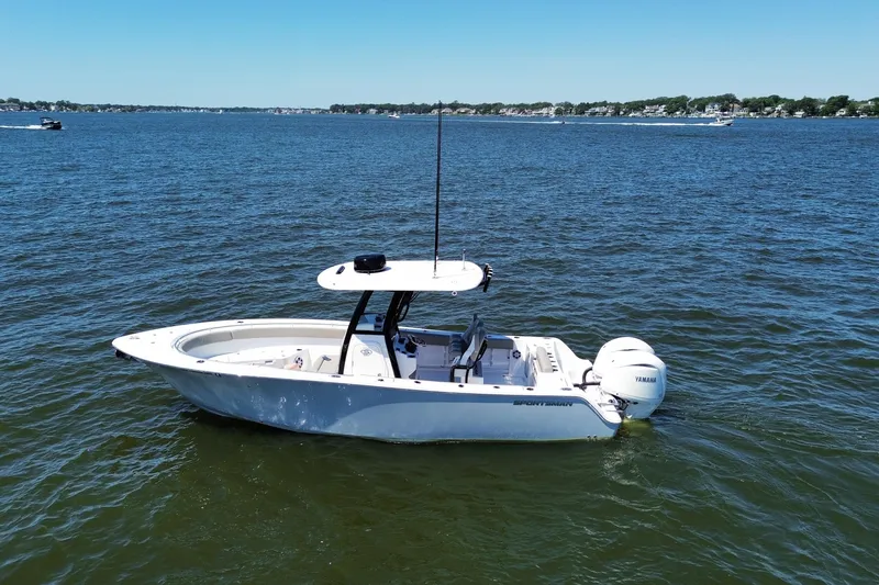 Slide: The Image of 2024 Sportsman Open 252 Center Console boat on calm water, clear sky background. - 9