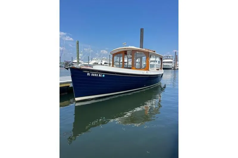 The Image of 2002 Duffy Electric 30 boat docked in a marina under a clear blue sky. - 0