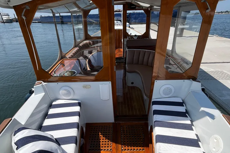 Slide: The Image of Interior of a 2002 Duffy Electric 30 boat with striped seating and wooden accents. - 14