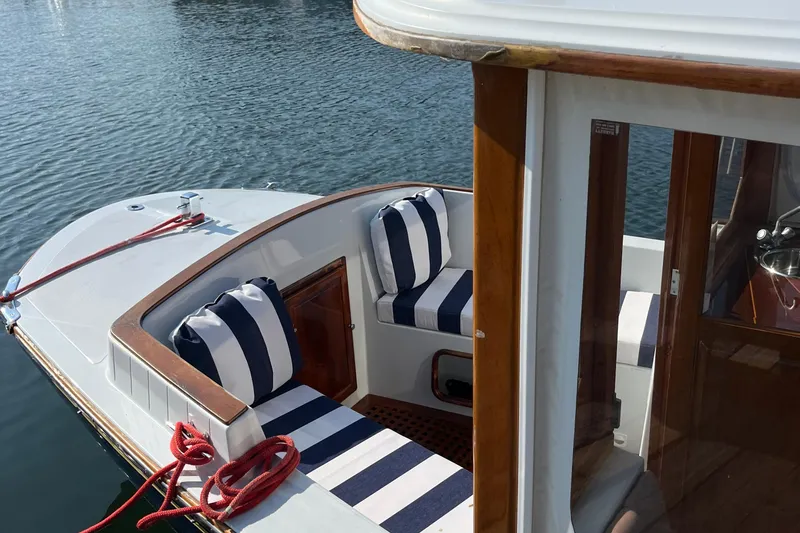 Slide: The Image of 2002 Duffy Electric 30 boat with striped seating, docked on calm water. - 15