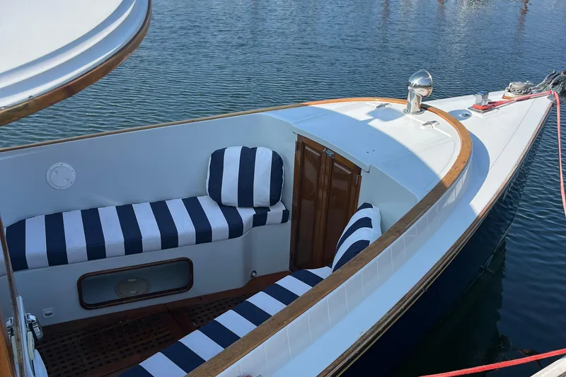 Slide: The Image of 2002 Duffy Electric 30 boat with striped seating on calm water. - 16