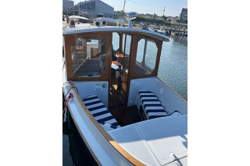 Slide: The Image of 2002 Duffy Electric 30 boat with striped seating, docked in a marina. - 3