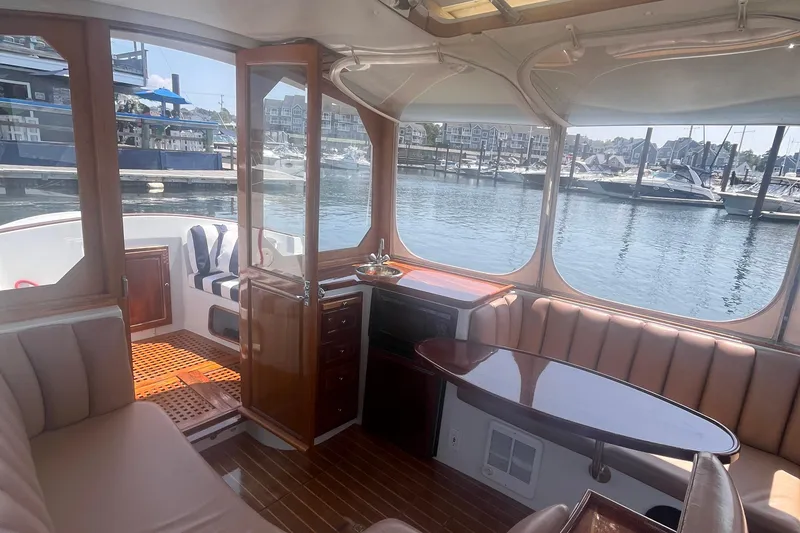 Slide: The Image of Interior of 2002 Duffy Electric 30 boat with elegant seating and marina view. - 5