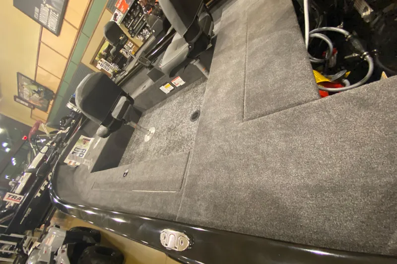 Slide: The Image of 2025 Tracker Super Guide V-16 T boat interior with gray carpet and seating. - 2