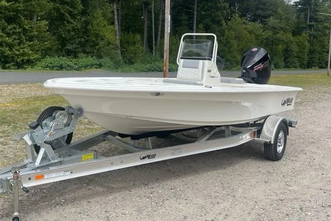 Slide: The Image of 2026 Mako 18 Pro Skiff on trailer, parked outdoors, with forest background. - 2