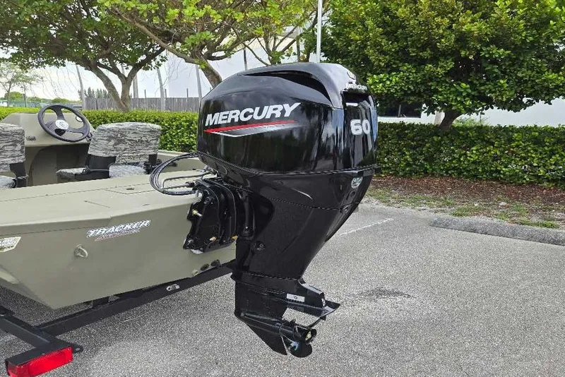 Slide: The Image of 2026 Tracker Grizzly 1754 SC boat with Mercury 60 outboard motor in a parking lot. - 4