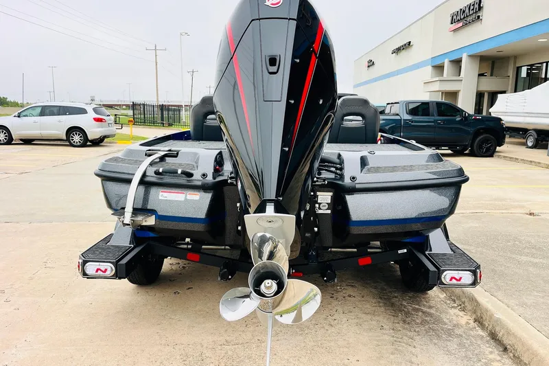 Slide: The Image of 2026 Nitro Z21 XL Pro boat rear view with motor and trailer in parking lot. - 64