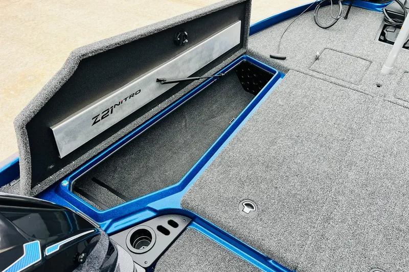 Slide: The Image of 2026 Nitro Z21 XL Pro boat interior with open storage compartment and carpeted flooring. - 75