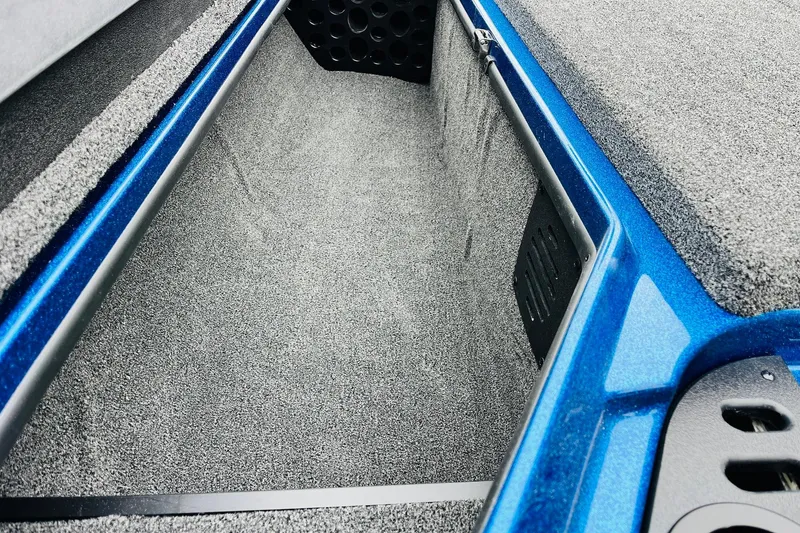 Slide: The Image of 2026 Nitro Z21 XL Pro boat storage compartment with blue trim and carpeted interior. - 76