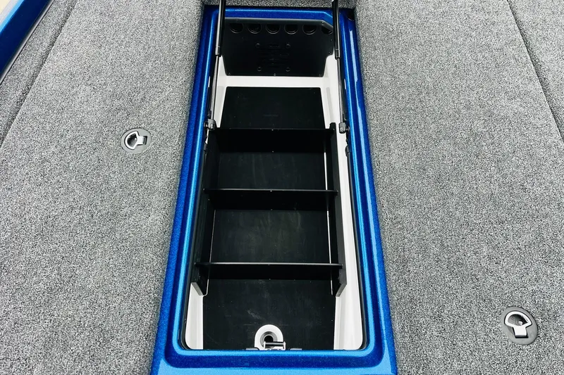 Slide: The Image of 2026 Nitro Z21 XL Pro boat storage compartment with blue trim and gray carpet. - 82
