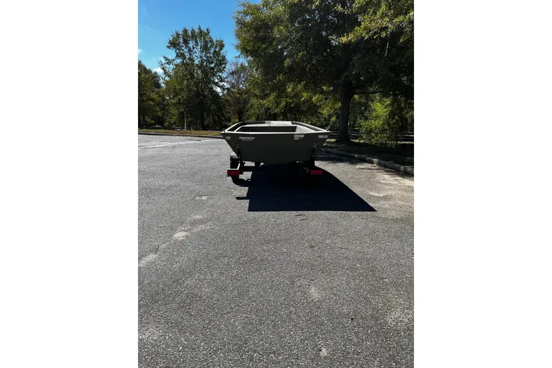 Slide: The Image of 2026 Tracker Grizzly 1648 Utility boat on trailer in sunny parking lot. - 2
