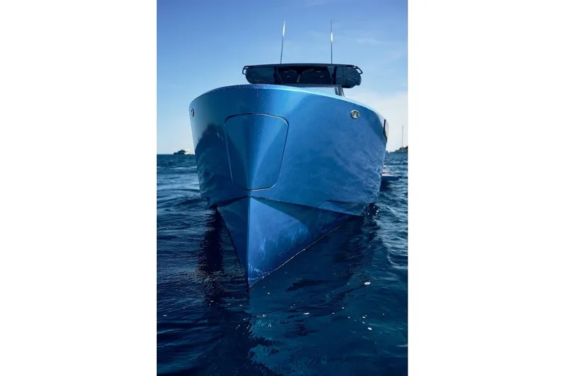Slide: The Image of 2026 Virtue V10 T-Top boat on calm blue water, front view. - 2