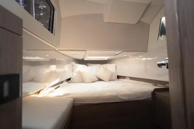Slide: The Image of Cozy interior cabin of 2026 Virtue V10 yacht with plush bedding and natural light. - 9