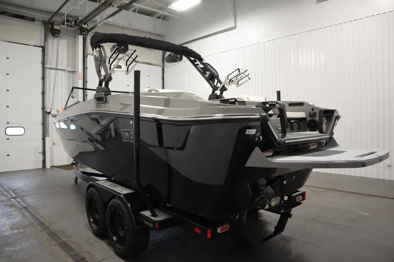 Slide: The Image of 2022 Heyday H22 boat in indoor storage, showcasing sleek design and dual-axle trailer. - 7