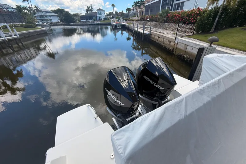 Slide: The Image of 2024 Beneteau Antares 11 with dual Mercury outboard engines docked in a serene canal. - 10