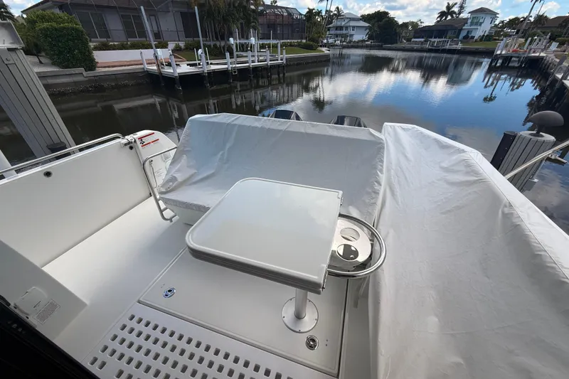 Slide: The Image of 2024 Beneteau Antares 11 boat deck with table, covered seating, and waterfront view. - 11