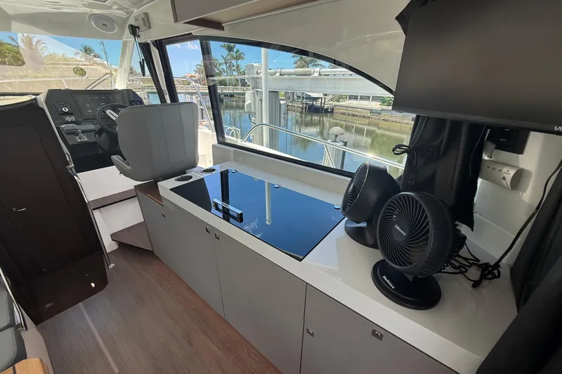 Slide: The Image of 2024 Beneteau Antares 11 interior with helm, seating, and modern amenities. - 13