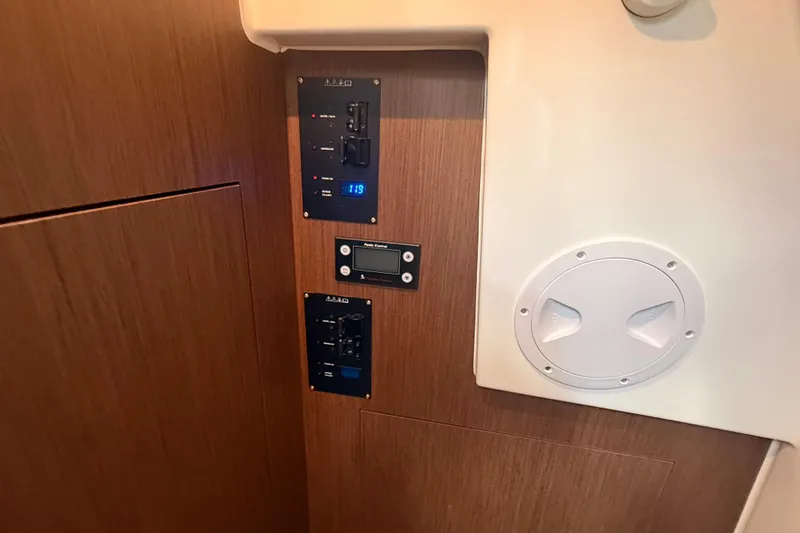 Slide: The Image of Control panel inside 2024 Beneteau Antares 11 boat, featuring wood finish and digital display. - 23