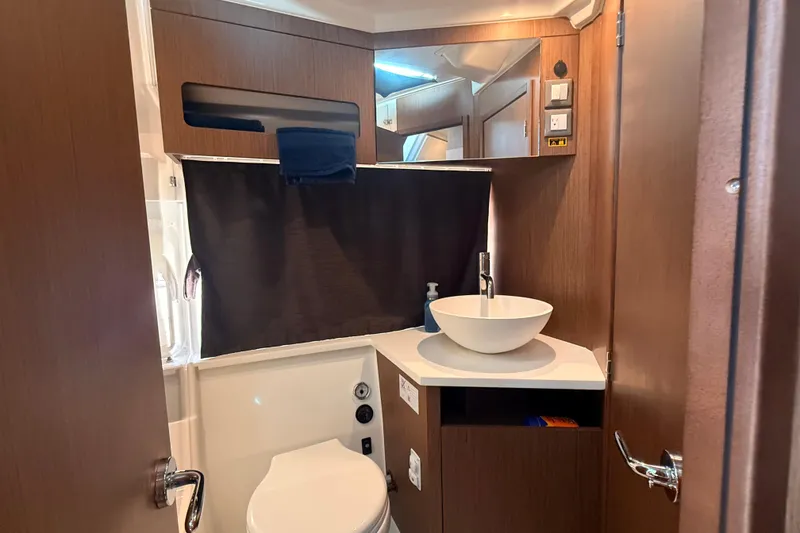 Slide: The Image of 2024 Beneteau Antares 11 bathroom with modern sink and wooden cabinetry. - 26