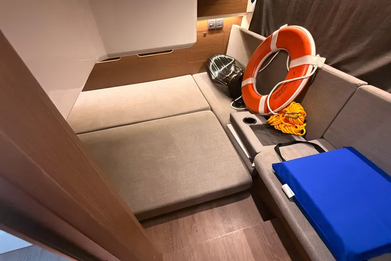 Slide: The Image of 2024 Beneteau Antares 11 interior with seating, life preserver, and safety equipment. - 27