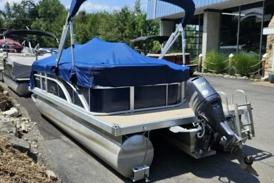 Slide: The Image of 2013 Bennington 20SLX pontoon boat with blue cover and outboard motor, parked outdoors. - 3