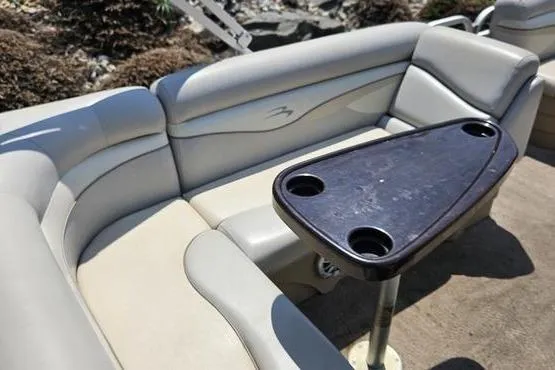 Slide: The Image of 2013 Bennington 20SLX boat interior with beige seating and a triangular table. - 9