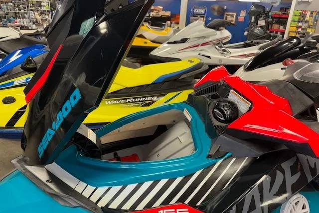 Slide: The Image of 2018 Sea-Doo Wake 155 jet ski with open storage compartment in showroom. - 9
