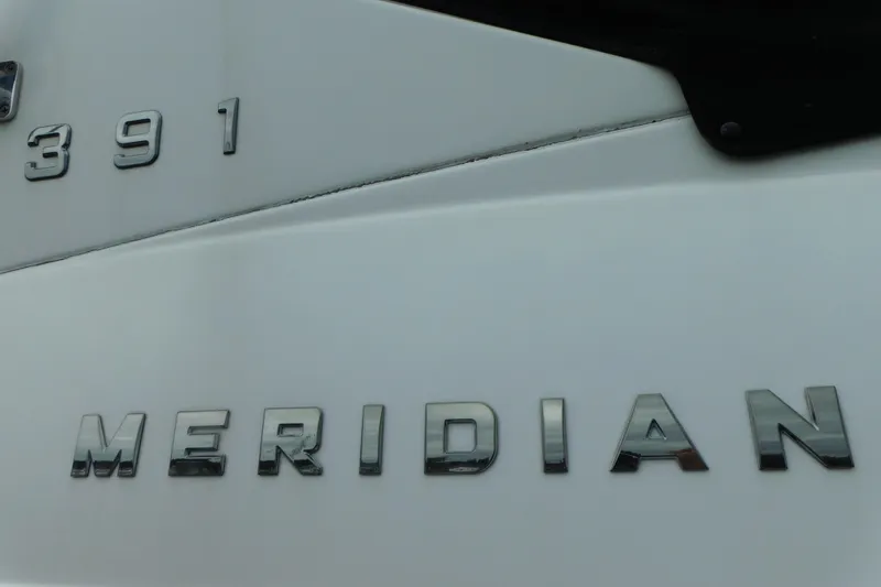 Slide: The Image of 2009 Meridian 391 Sedan boat nameplate with chrome lettering on white surface. - 12