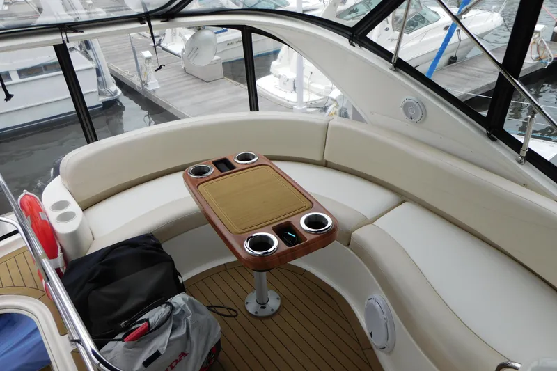 Slide: The Image of 2009 Meridian 391 Sedan yacht interior with curved seating and wooden table at marina. - 20