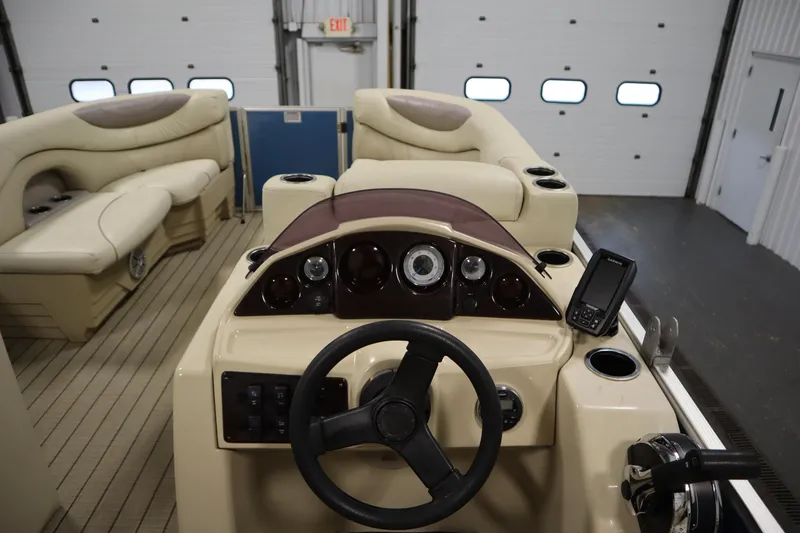 Slide: The Image of Interior of a 2018 Sylvan 820 Mirage boat with beige seating and control panel. - 18