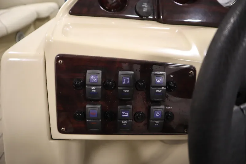 Slide: The Image of Control panel of a 2018 Sylvan 820 Mirage boat with various switches. - 22