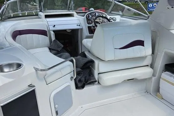 Slide: The Image of 1997 Chris-Craft 30 Crowne boat interior with white seating and dashboard controls. - 6