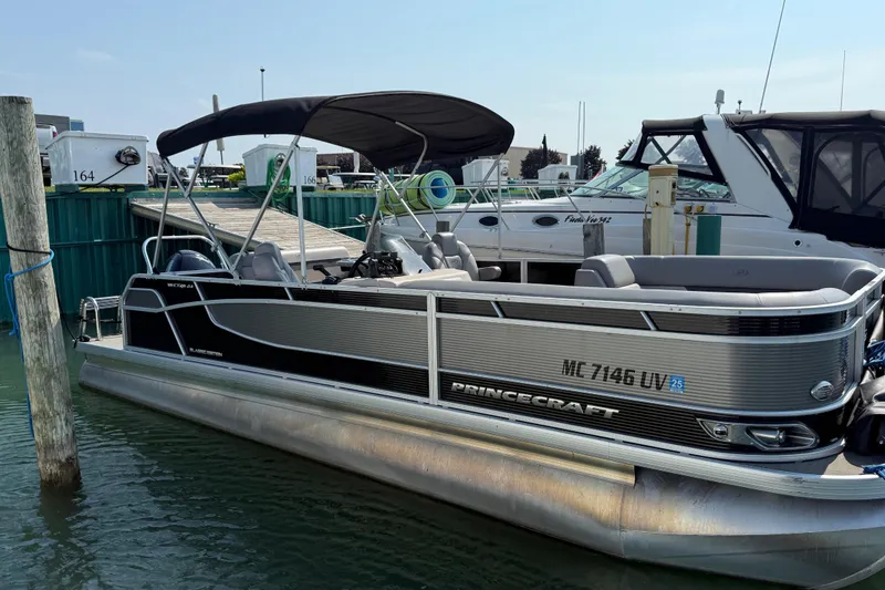 Slide: The Image of 2022 Princecraft Vectra 23 RL pontoon boat docked at marina. - 0