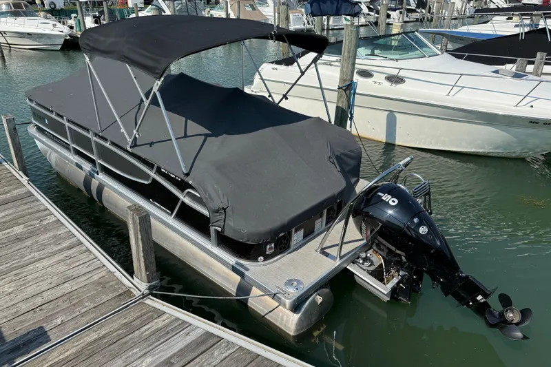 Slide: The Image of 2022 Princecraft Vectra 23 RL pontoon boat docked with black canopy and outboard motor. - 20
